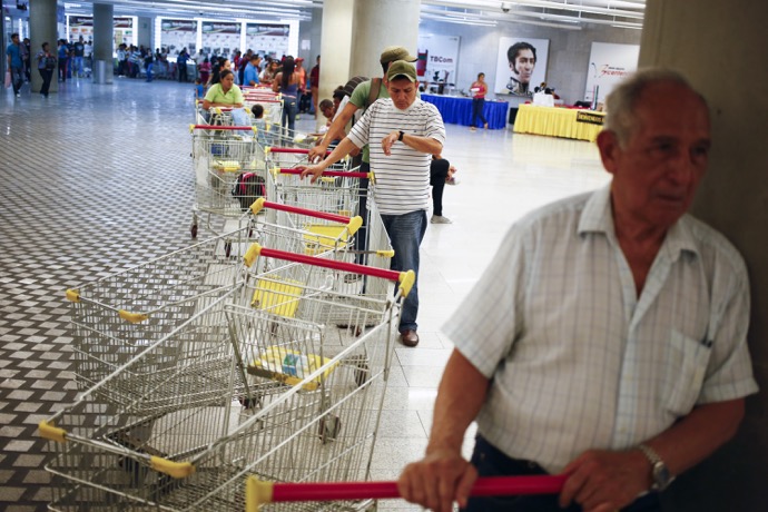 Customers line up to get in for shopping at a state-run Bicentenario supermarket in Caracas